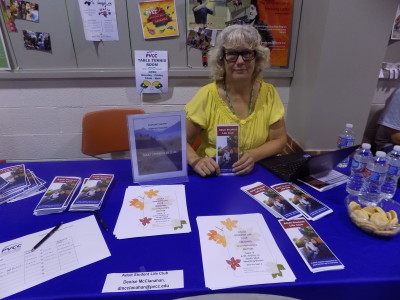 Club member poses with information at club table