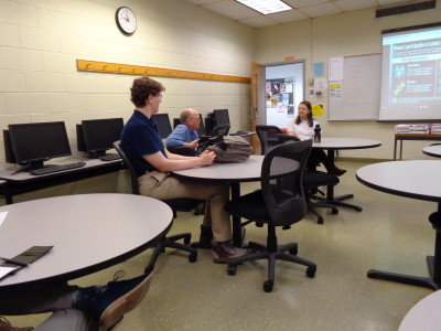 Meeting attendees discussing engineering. Photography by Charles Stish