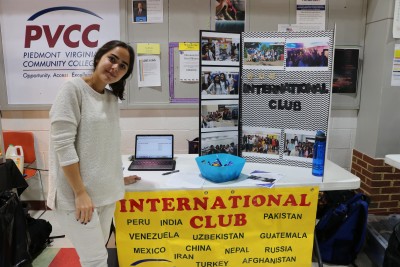 student poses at club day table