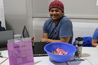 student poses at club day table