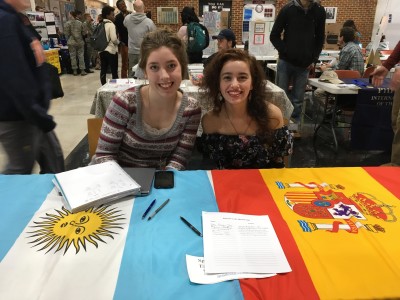 Gigi Gett poses with another student at club day table with flags