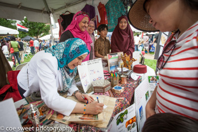 A woman signing a book at the Festival of Cultures. Photo courtesy of Zakira Beasley.