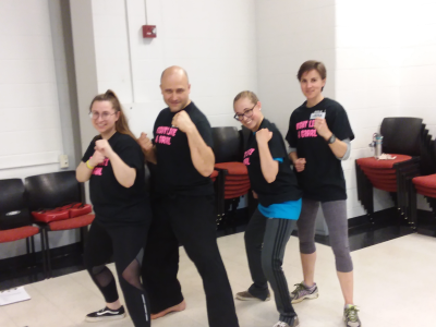 Four people posing for the camera showing their punching stances. Photo by Deadra Miller.