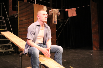 A young man sits on the see-saw looking contemplative. 