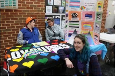 students post at LGBTQA club table