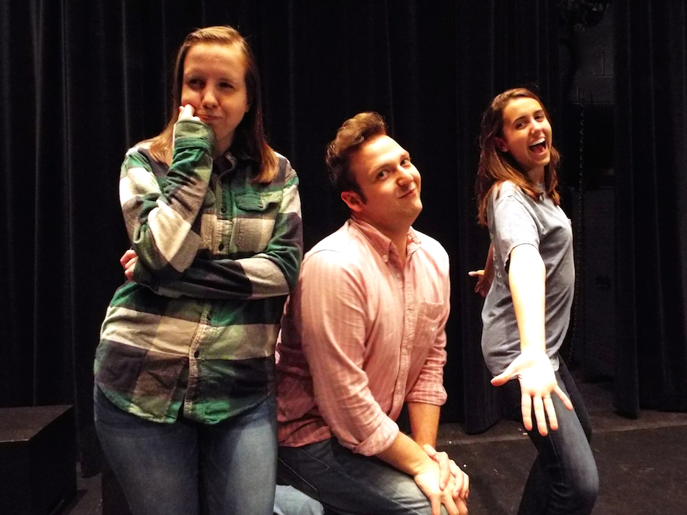 3 students pose in the black box theater