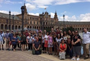 Students stand in front of a building in Spain.