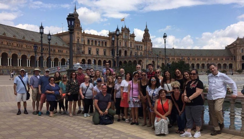 Students stand in front of a building in Spain.
