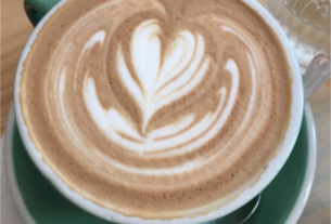 A cup of cappuccino with a design in the foam