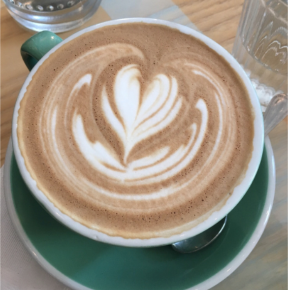 A cup of cappuccino with a design in the foam