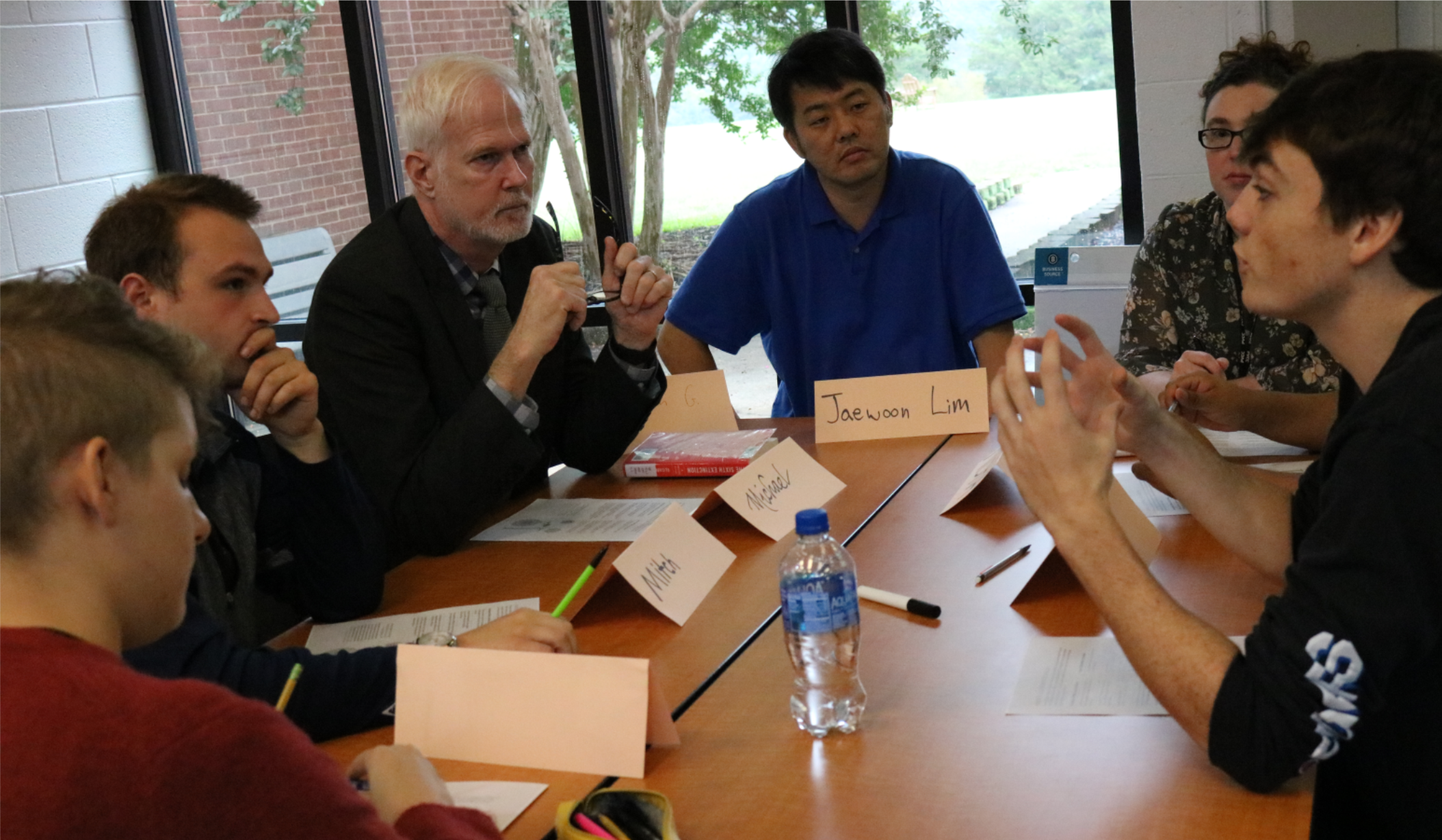 Students and community members talk around a table