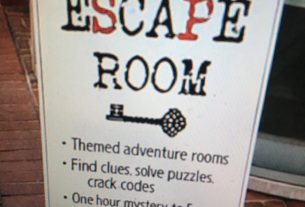 C-Ville Escape Room sign on brick. Various text.