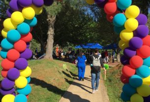 People attending Spring Fling pass under a colorful balloon arch.