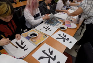 Nina Brooks receives help as she performs calligraphy.