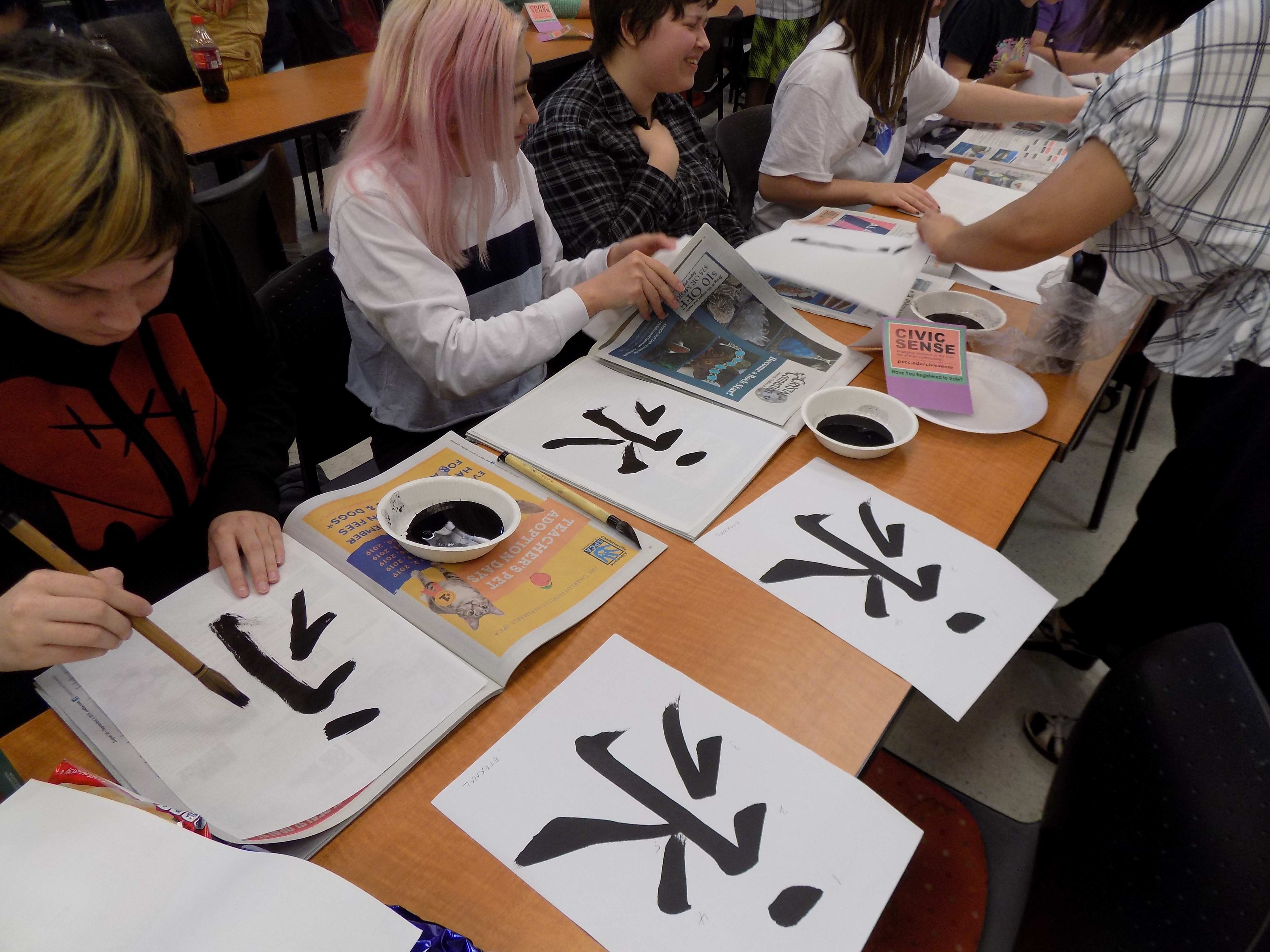 Nina Brooks receives help as she performs calligraphy.