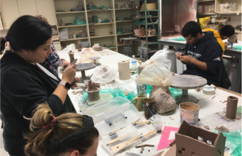 Students working on their pottery pieces during class