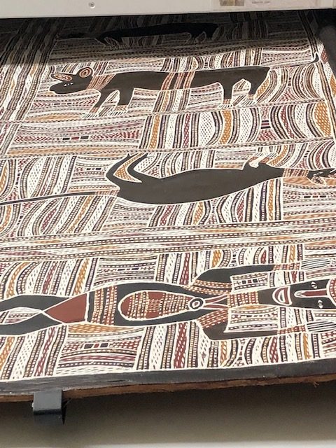 Aboriginal art depicting a human and two four-legged animals.