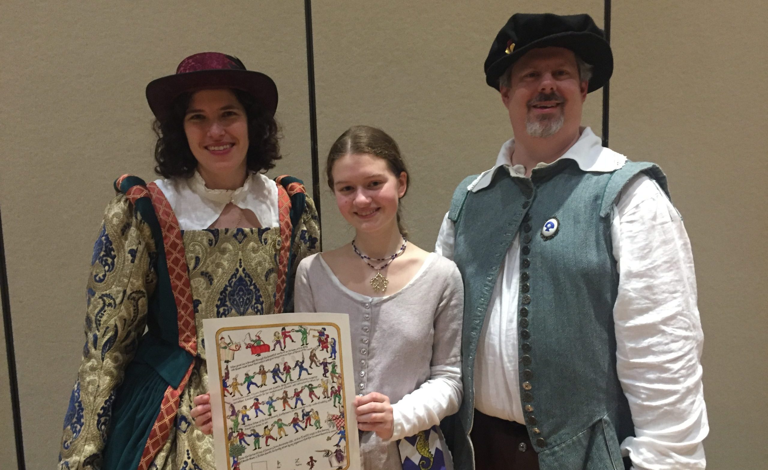 Zmick, standing in medieval attire with two other members of her reenactment group. Zmick is holding an award decorated with drawings of medieval dancers.