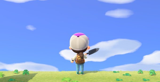 The player character from Animal Crossing stands on a grassy hill with their back facing the camera, shovel in hand. They are looking at the bright blue sky.