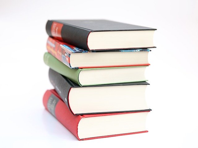 A stack of textbooks with a white background. Picture courtesy of Pixabay.