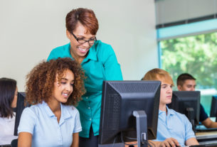 Teacher with students on computers