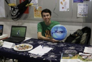 PVCC student poses on Club Day at Ultimate Frisbee Club table