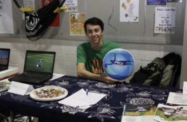 PVCC student poses on Club Day at Ultimate Frisbee Club table