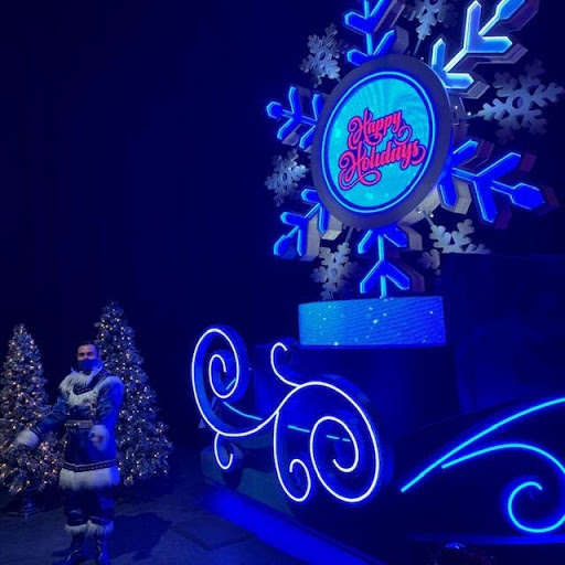 A large snowflake illuminated with blue lights reads "happy holidays"