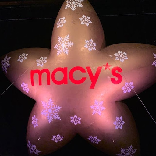 A star shaped Macy's balloon illuminated in the night