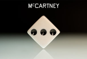 the name "McCartney" in white lettering hovers above a white dice with three black pips