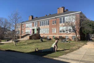 A photo of the McGuffey Art Center, a large brick building with an assortment of statues on the lawn out front