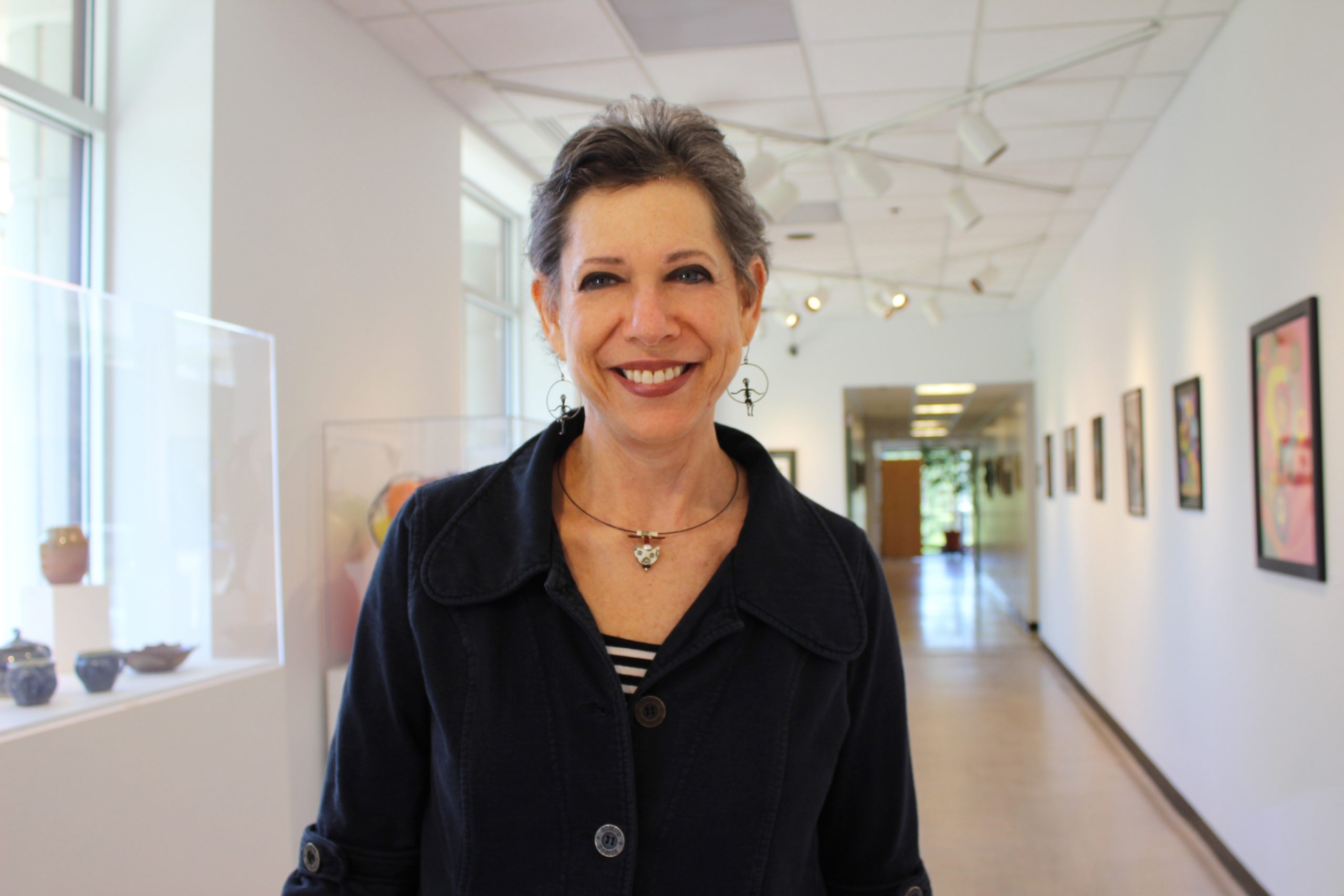 Bryl Solla, a kind looking woman with short gray hair, beams at the camera.