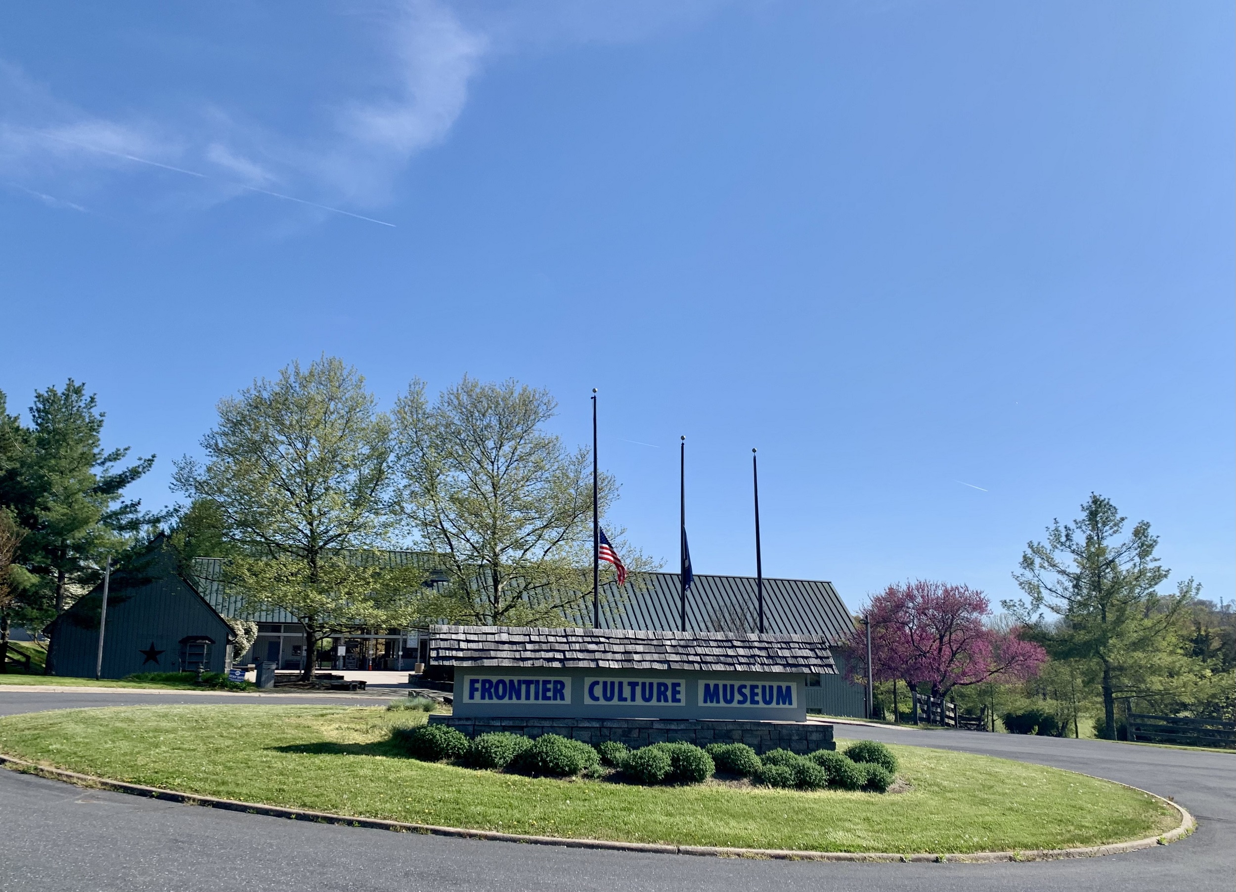 View of the main entrance sign for the museum adorner with flags and flowers