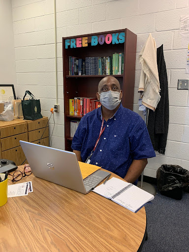 Academic Coach James Bryant, clad in a blue shirt,sits in his chair at the writing center