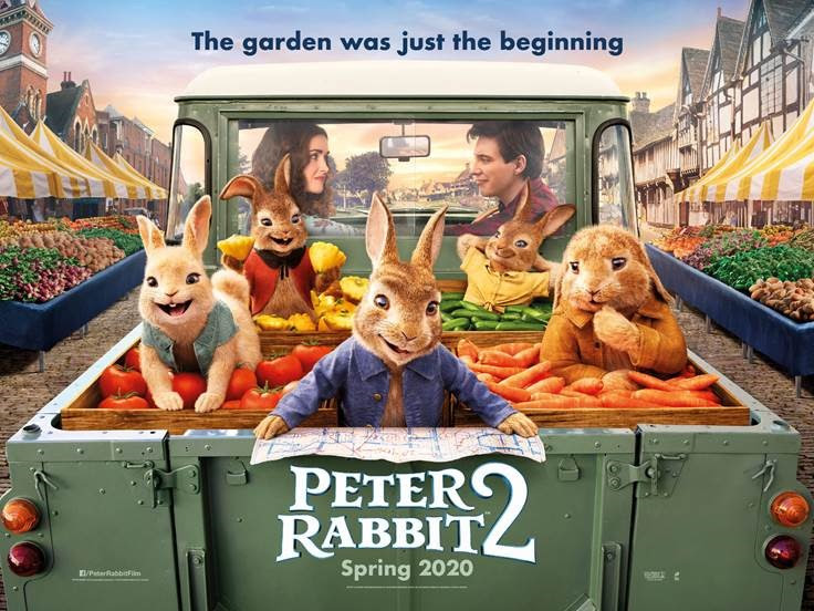 Four smiling bunnies wearing clothing ride in the back of a truck with vegetables. The two human leads are looking at each other in the front seat. Above it it reads, "The Garden was just the beginning." At the bottom of the image it says, "Peter Rabbit 2 Spring 2020"