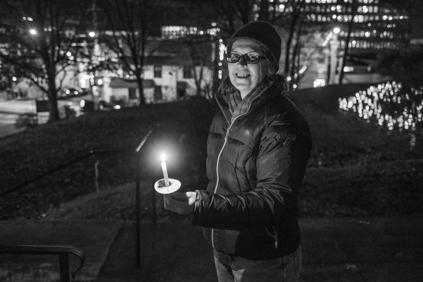 A black and white photo of Fenella Belle holding a candle at the 2021 PVCC Let There Be Light Exhibit