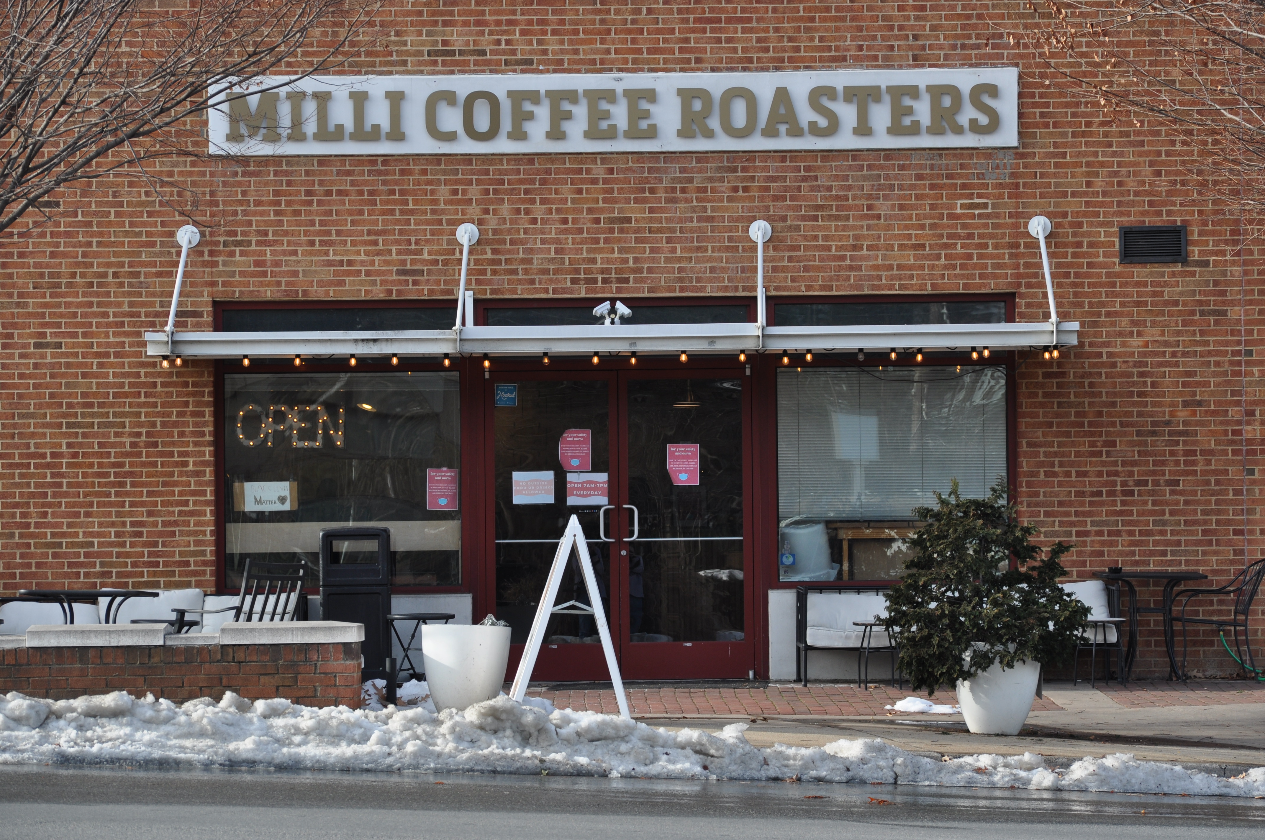 The front of a building with snow clustered outside and a sign reading "Milli Coffee Roasters"
