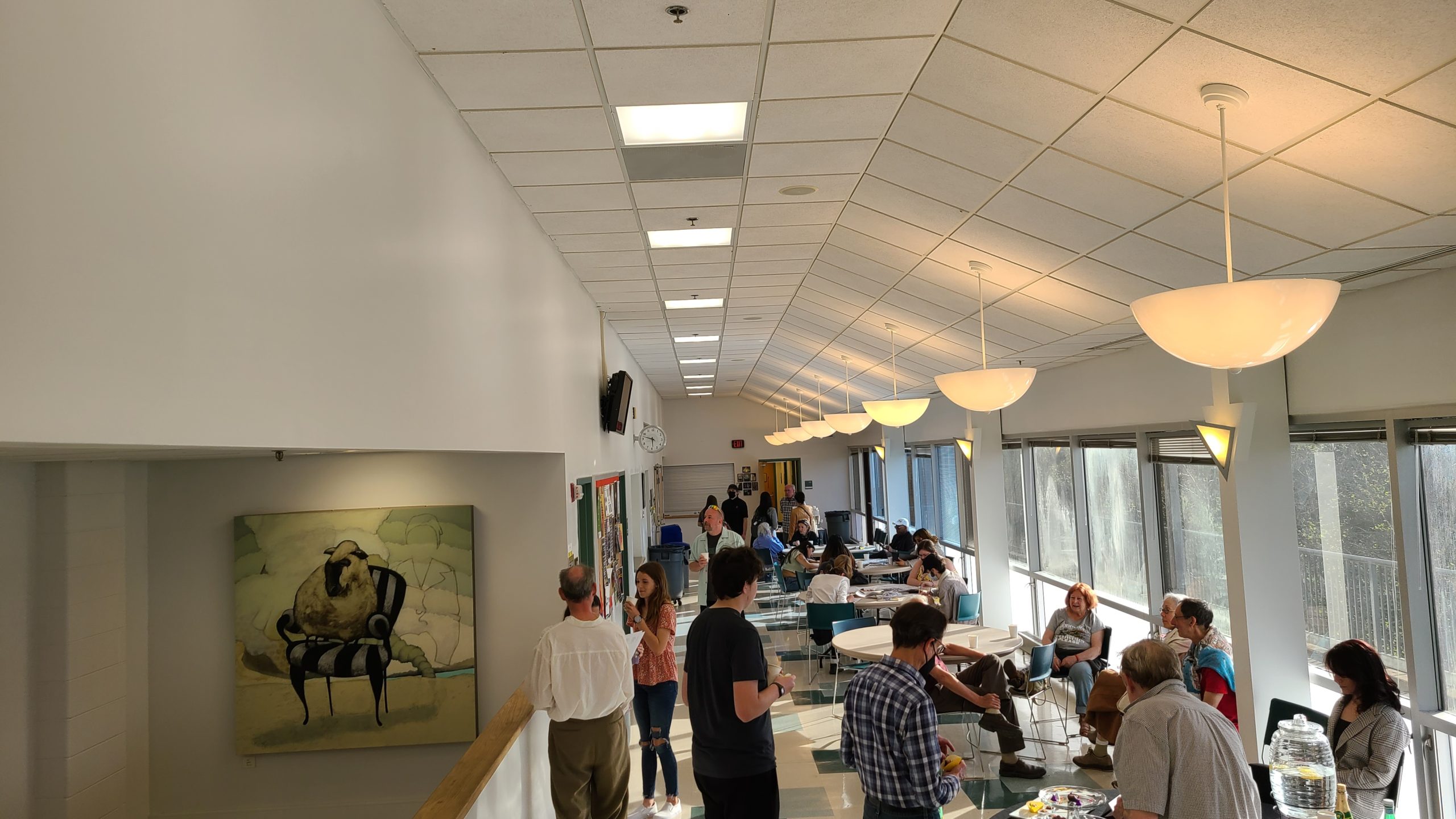 Attendees gather on the west hall pavilion of the PVCC Dickinson Building. Attendees are sitting, standing, chatting, eating chocolate, and drawing.