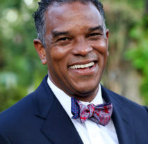 Dr. Walt Tobin smiles at the camera in a suit and bowtie.