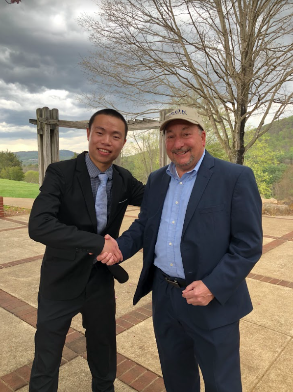 Johnson Li shakes hands with PVCC President Frank Friendman on the student patio on a cloudy day