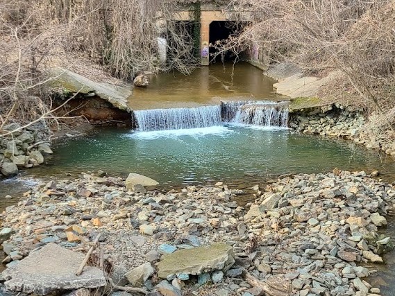 River leading to a split over rocks. A river underpass is visible.