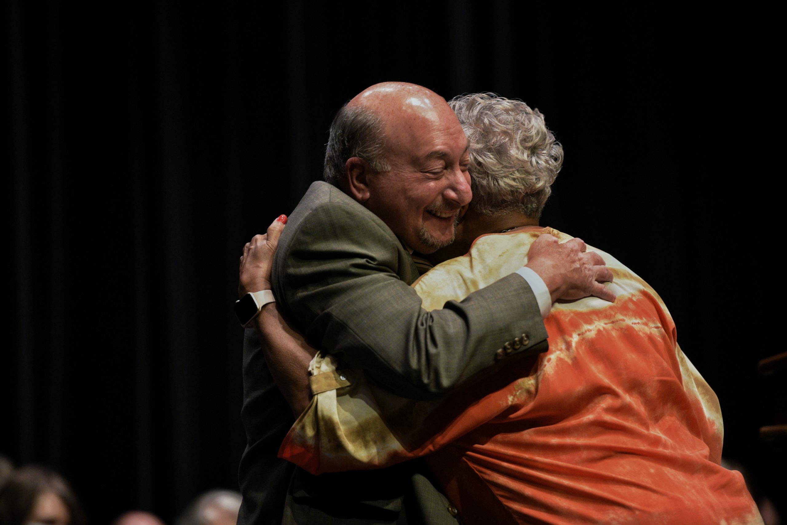 Dr. Frank Friedman hugs college board chair Lola Richardson