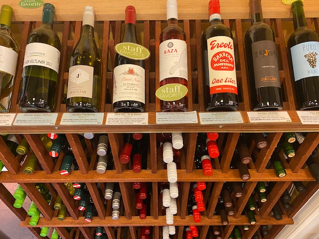 a wooden wine rack with a variety of bottles of wine