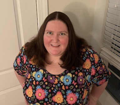 Dr. Tamara Whyte posing for the camera with a colorful flower print shirt on.