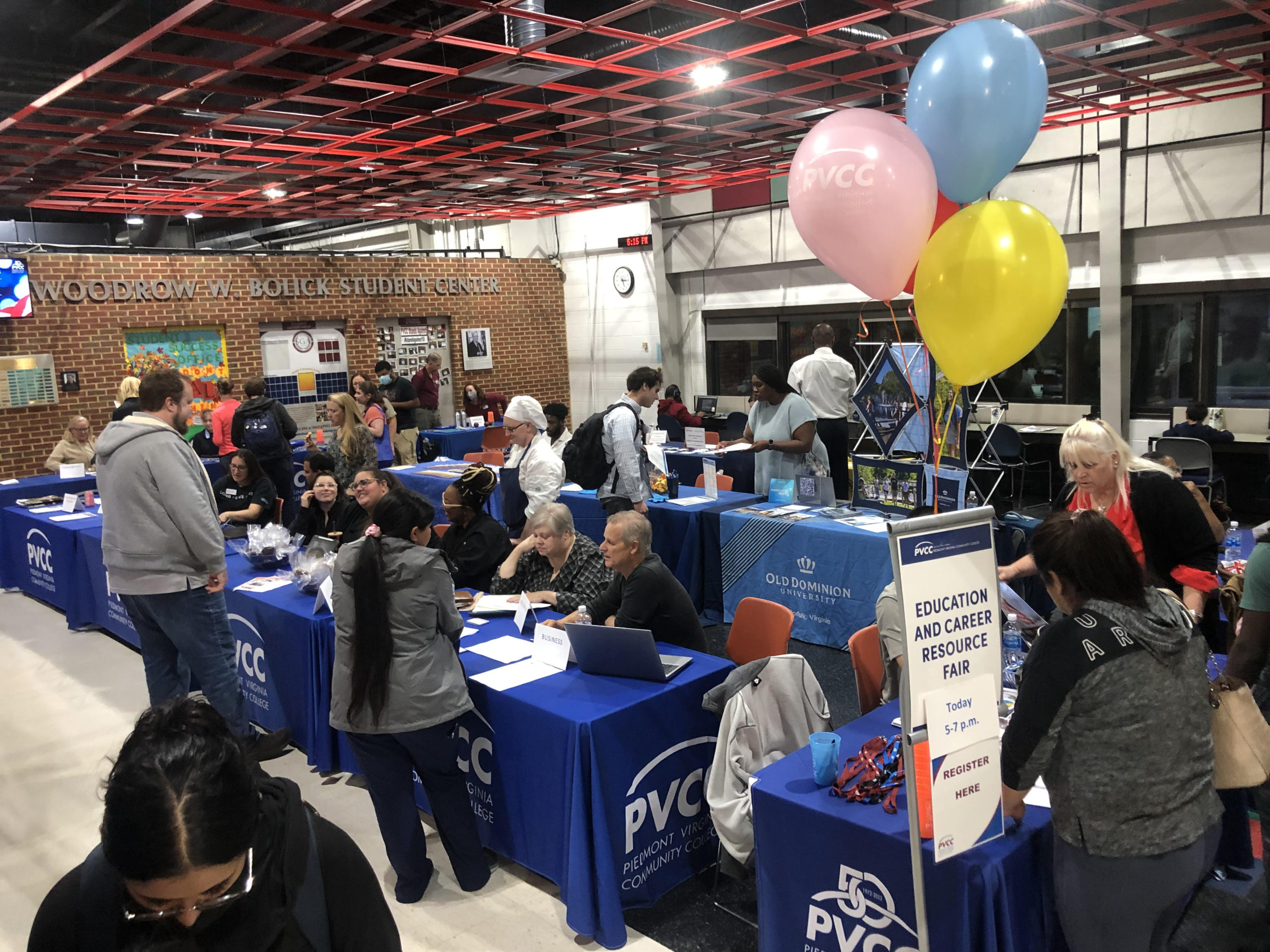 Table setups and fair-goers at the Education and Resource Fair.