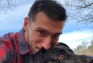 Philosophy professor Stephen Marrone smiling with his dog while outside.