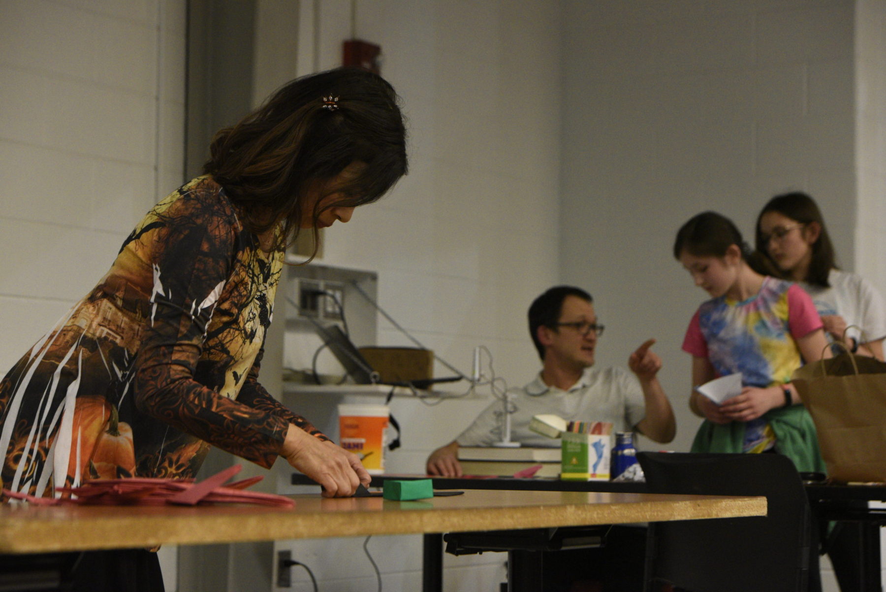 a woman bends over the table folding paper