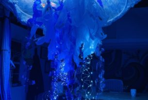 A blue sculpture of a jellyfish with lights shining in it