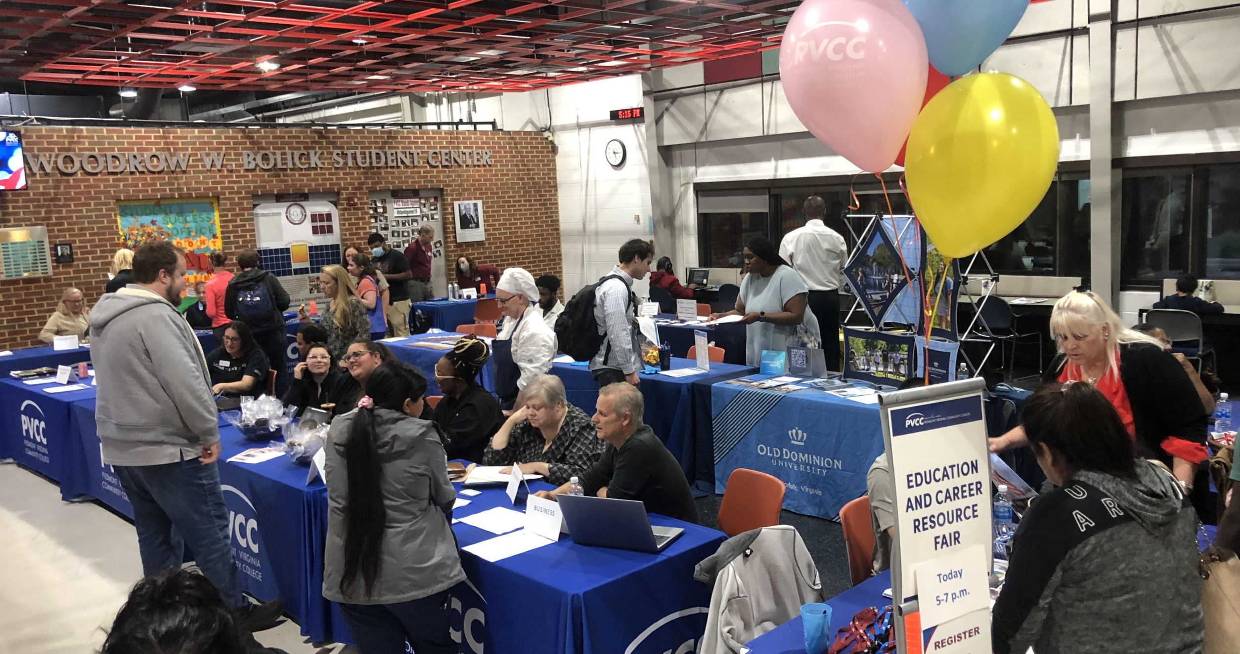 The Bolick Student Center crowded with tables. Fair goers converse with department representatives sat at these tables. A sign in the foreground reads "Education and Career Resource Fair"