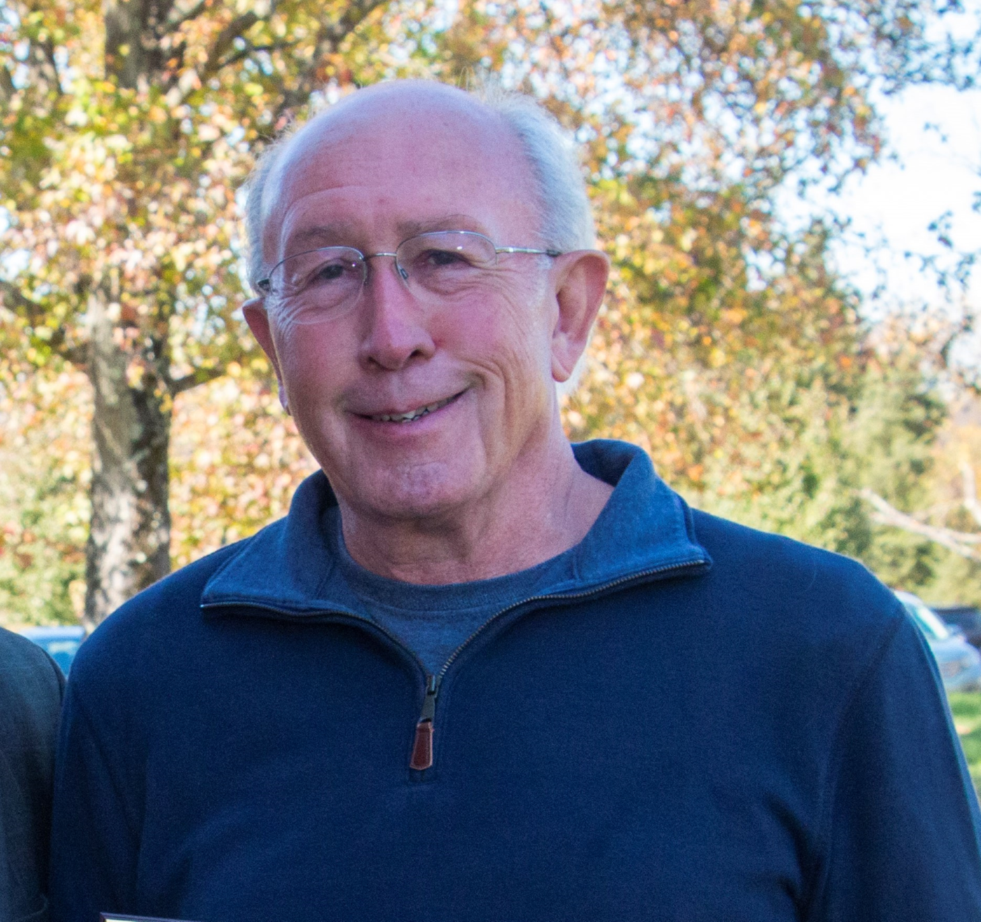 A man in glasses wearing a blue sweater